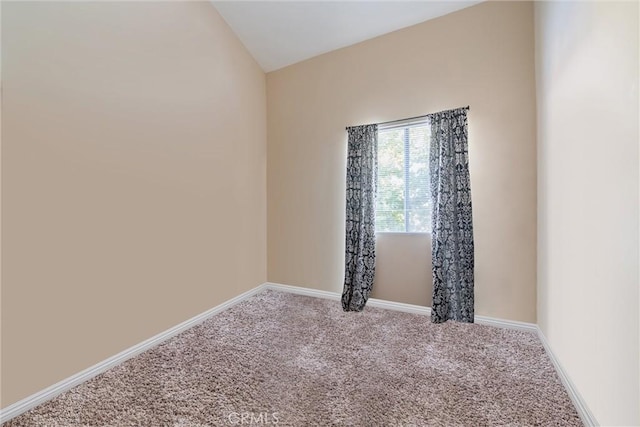 empty room featuring carpet flooring and vaulted ceiling