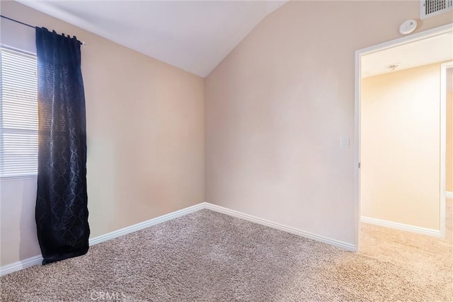 carpeted spare room featuring lofted ceiling