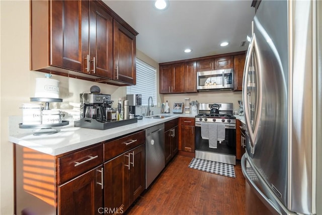 kitchen with dark wood-type flooring, stainless steel appliances, and sink