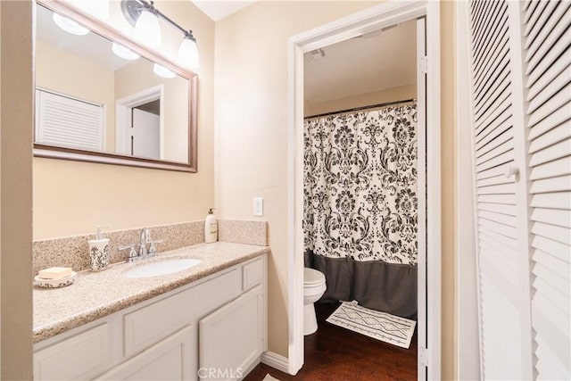 bathroom with wood-type flooring, toilet, vanity, and walk in shower