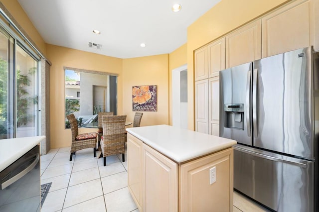 kitchen featuring light tile patterned floors, appliances with stainless steel finishes, and a center island