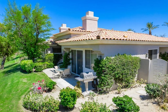 rear view of property with a patio area and a yard