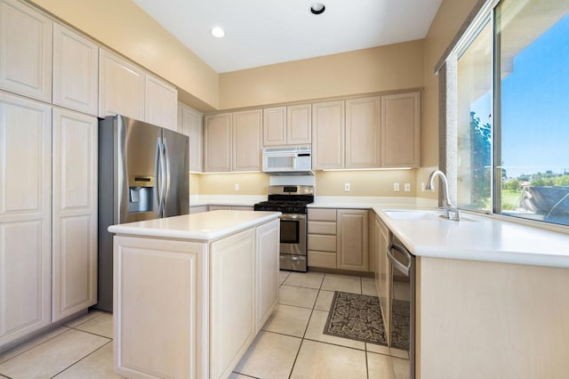 kitchen featuring light tile patterned floors, appliances with stainless steel finishes, sink, and a center island