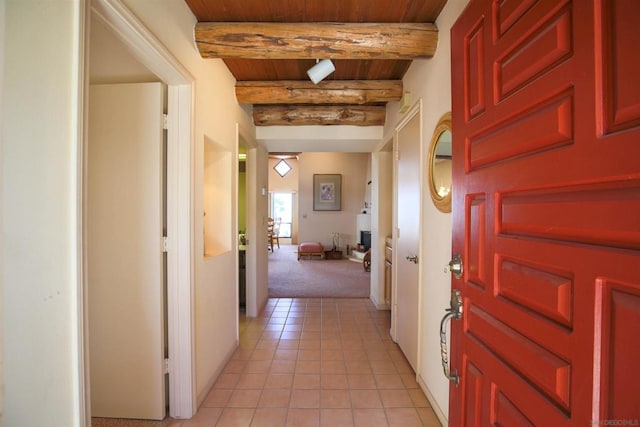 hallway featuring wooden ceiling, light colored carpet, and beamed ceiling