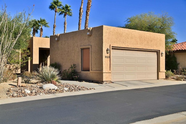 pueblo revival-style home featuring a garage