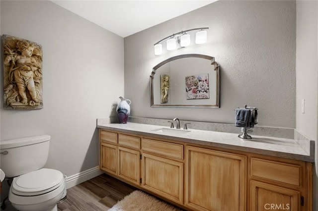 bathroom featuring toilet, wood-type flooring, and vanity