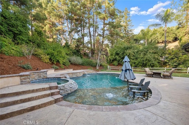 view of pool featuring pool water feature, a patio area, and an in ground hot tub