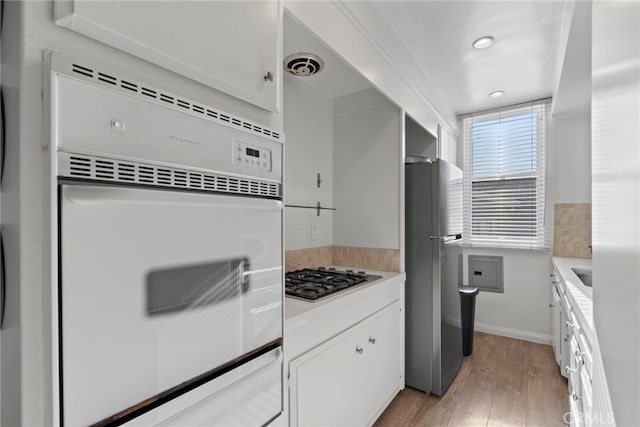 kitchen with white cabinetry, light wood-type flooring, and appliances with stainless steel finishes