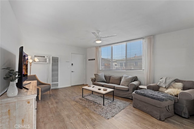 living room with a wall unit AC, ceiling fan, and light hardwood / wood-style flooring