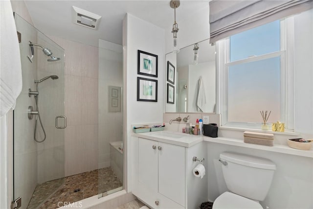 bathroom featuring an enclosed shower, vanity, and toilet