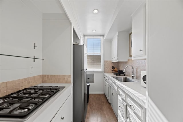 kitchen featuring appliances with stainless steel finishes, sink, white cabinets, and backsplash