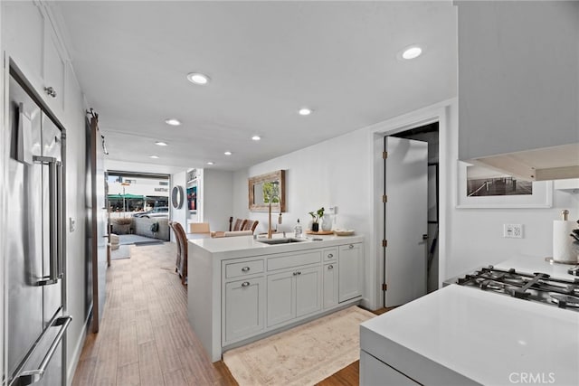 kitchen featuring gray cabinetry, sink, light hardwood / wood-style flooring, and high end fridge