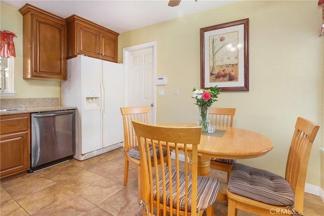 tiled dining space featuring ceiling fan and sink