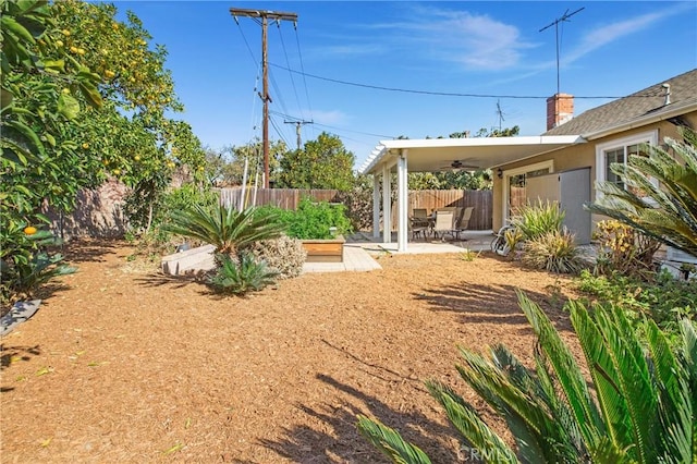 view of yard with ceiling fan and a patio area