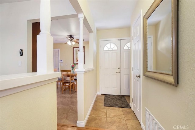 tiled entryway with ornate columns and ceiling fan