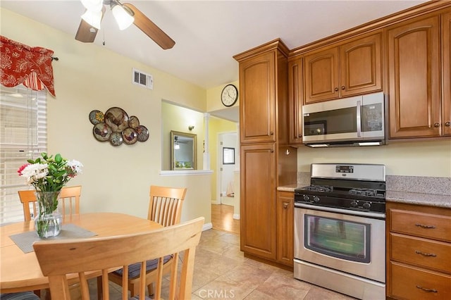 kitchen with ceiling fan, light tile patterned floors, and stainless steel appliances