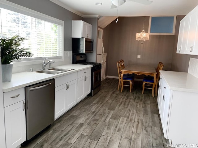 kitchen featuring sink, white cabinetry, hanging light fixtures, and appliances with stainless steel finishes