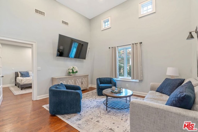 living room featuring wood-type flooring and a high ceiling