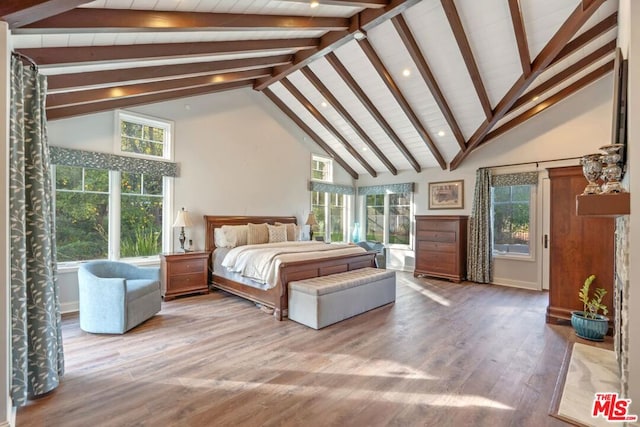 bedroom featuring multiple windows, hardwood / wood-style floors, and high vaulted ceiling