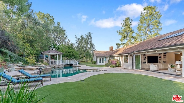 view of swimming pool featuring a gazebo, an in ground hot tub, a patio, and a lawn