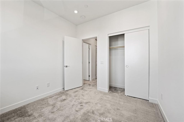 unfurnished bedroom with light carpet and a closet