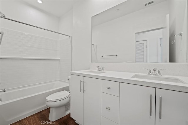 full bathroom with hardwood / wood-style floors, toilet, vanity, and bathing tub / shower combination