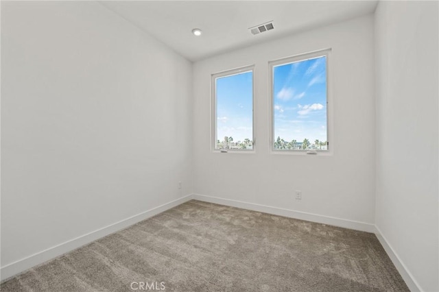 spare room featuring light colored carpet