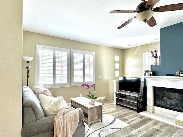 living room with light wood-type flooring and ceiling fan