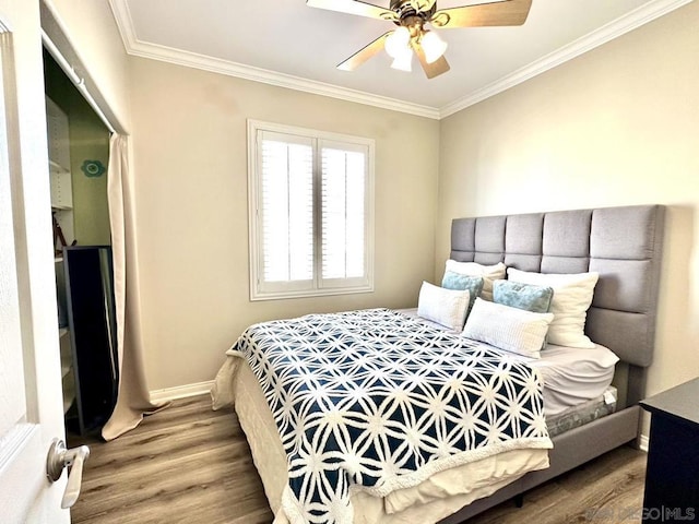 bedroom with ceiling fan, ornamental molding, and wood-type flooring