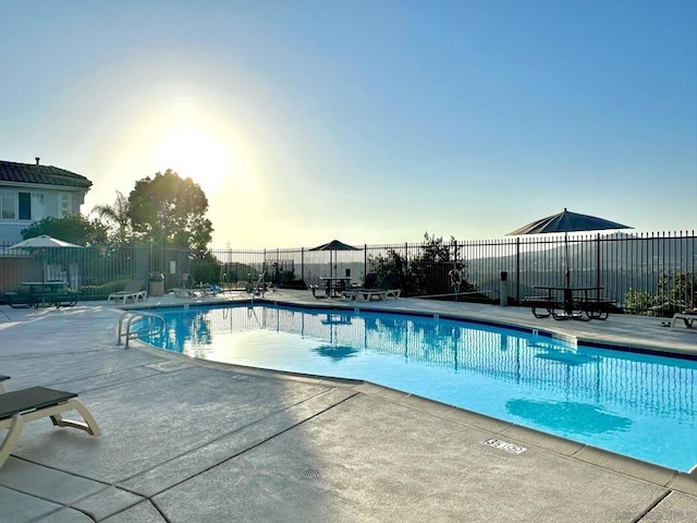 pool at dusk featuring a patio