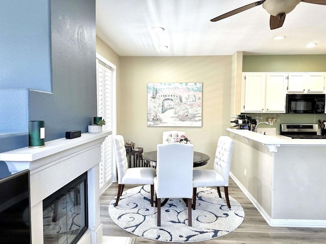 dining space featuring ceiling fan and light wood-type flooring