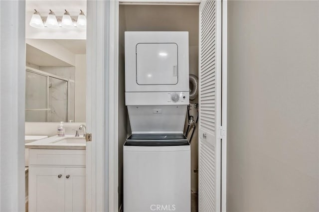 washroom with stacked washer / drying machine and sink