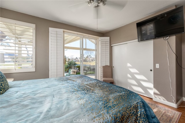 bedroom with ceiling fan, access to exterior, and hardwood / wood-style floors