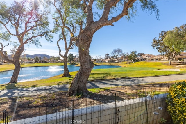 exterior space with a water and mountain view and a lawn