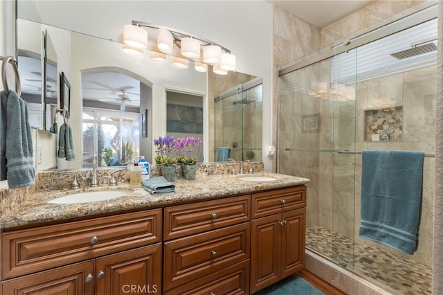 bathroom featuring ceiling fan, walk in shower, and vanity