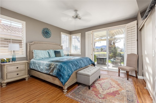 bedroom featuring ceiling fan, access to exterior, and light hardwood / wood-style flooring