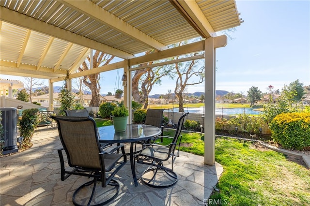 view of patio / terrace featuring a water view, cooling unit, and a pergola