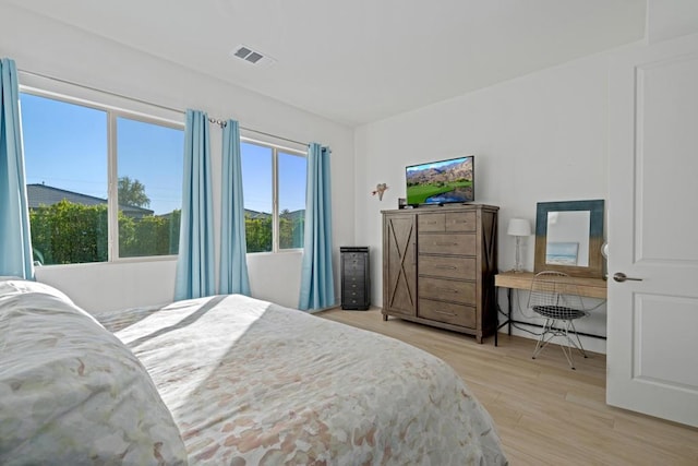 bedroom with light hardwood / wood-style flooring and multiple windows