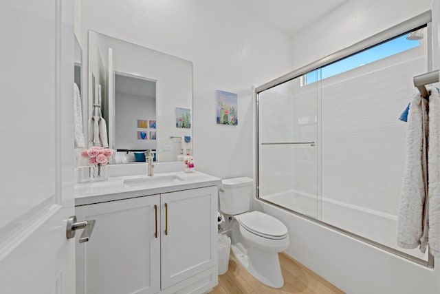 full bathroom featuring bath / shower combo with glass door, wood-type flooring, toilet, and vanity