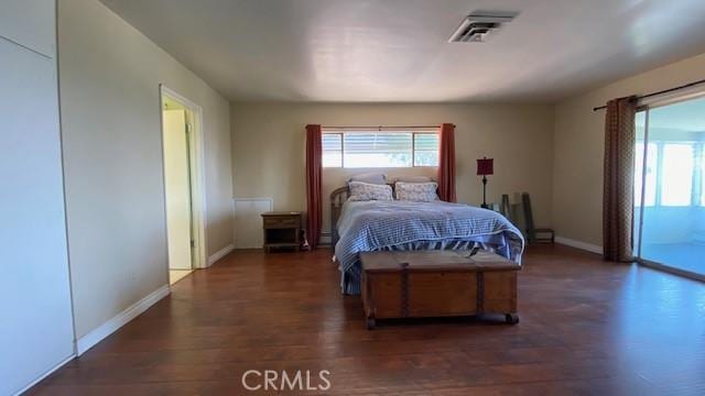 bedroom featuring dark wood-type flooring and access to exterior