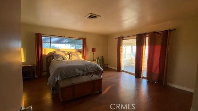 bedroom with access to exterior and dark hardwood / wood-style flooring