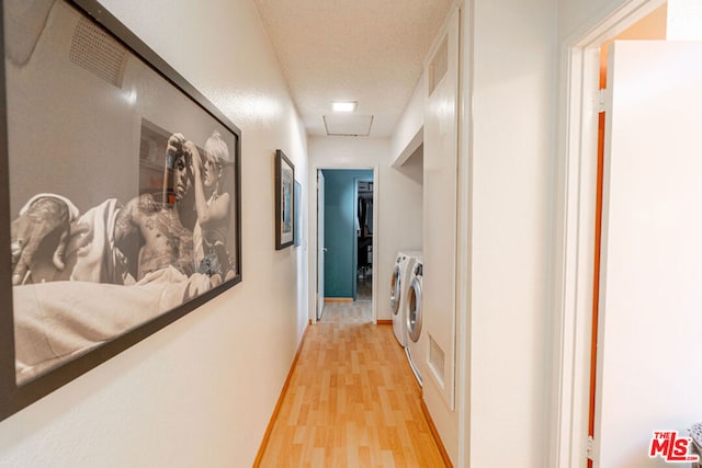 corridor featuring washer and clothes dryer and light wood-type flooring