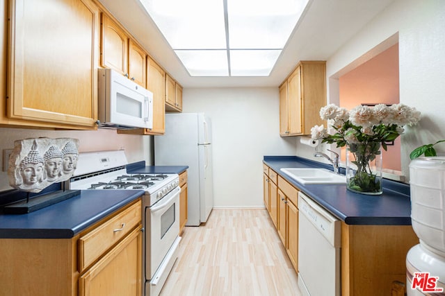 kitchen with light wood-type flooring, sink, light brown cabinets, and white appliances