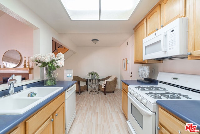 kitchen with light brown cabinets, sink, white appliances, and light hardwood / wood-style floors