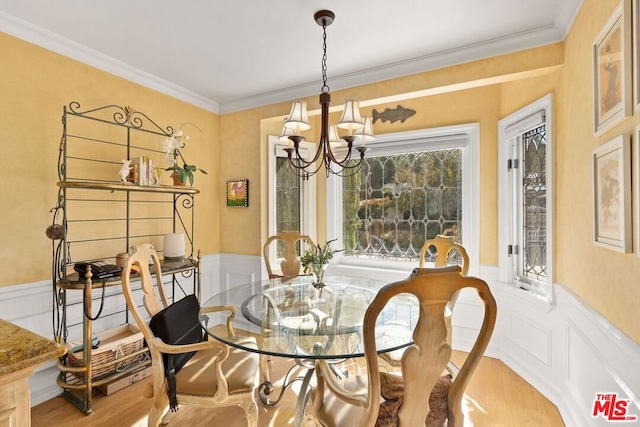 dining space featuring ornamental molding, light hardwood / wood-style flooring, and a notable chandelier