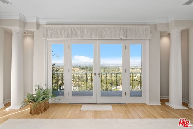 doorway to outside with hardwood / wood-style flooring, plenty of natural light, and ornamental molding