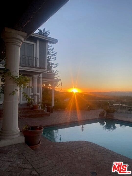 pool at dusk with a patio