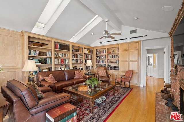 living room featuring ceiling fan, vaulted ceiling with beams, built in shelves, and light hardwood / wood-style floors