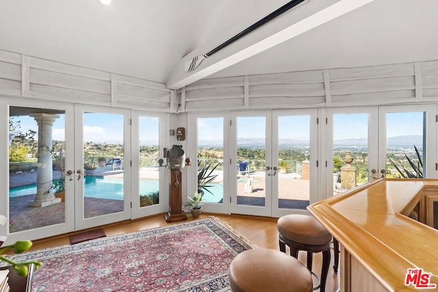 sunroom featuring lofted ceiling and french doors