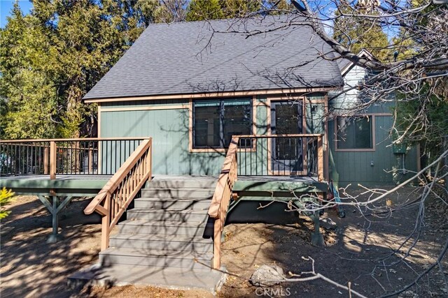 rear view of property featuring a wooden deck